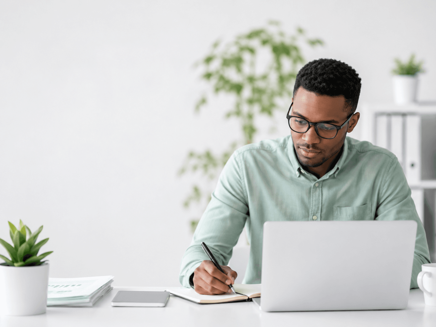 A school administrator taking notes while working at a laptop